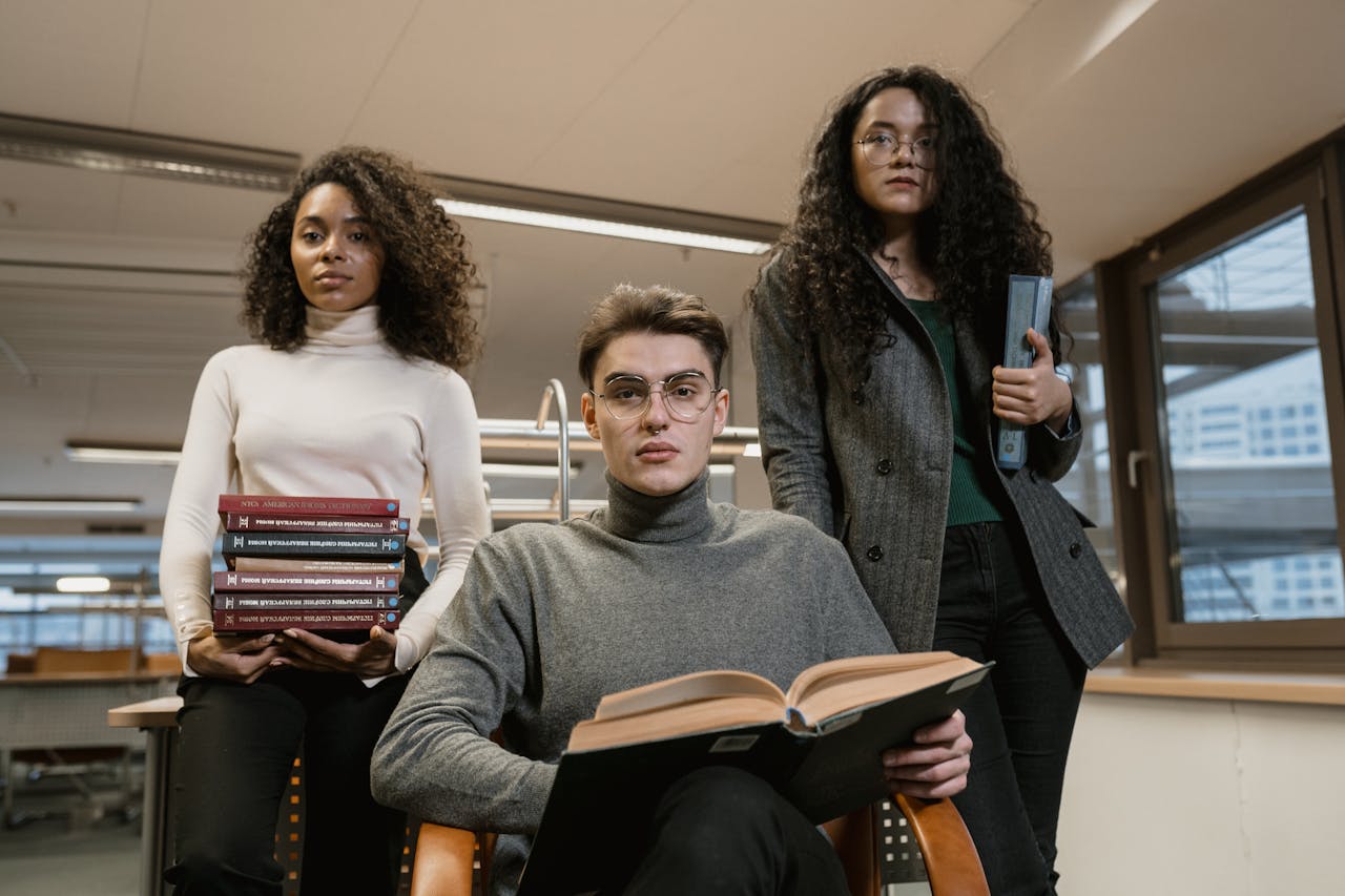 Group of diverse college students studying together in a modern library setting.